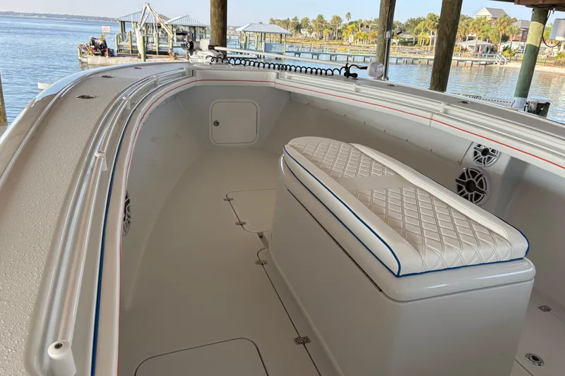 Slide: The Image of 2024 Yellowfin 36 Offshore boat interior with cushioned seating and waterfront view. - 10