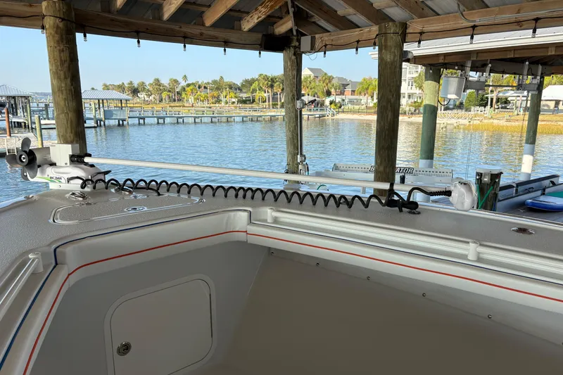 Slide: The Image of 2024 Yellowfin 36 Offshore boat docked under a wooden canopy by the waterfront. - 12