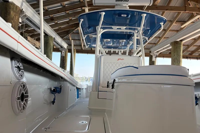 Slide: The Image of 2024 Yellowfin 36 Offshore boat interior with blue accents under a wooden dock. - 14