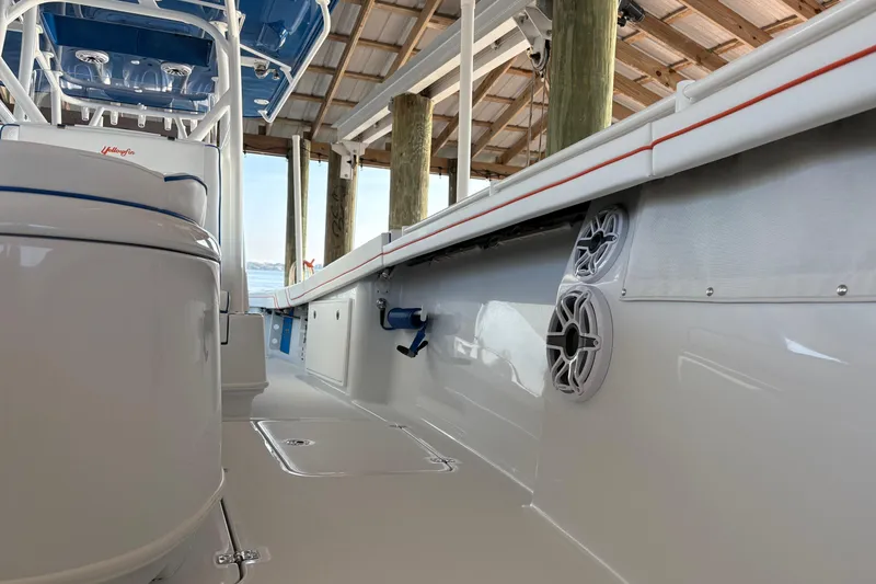 Slide: The Image of 2024 Yellowfin 36 Offshore boat interior with speakers and seating under a dock. - 15