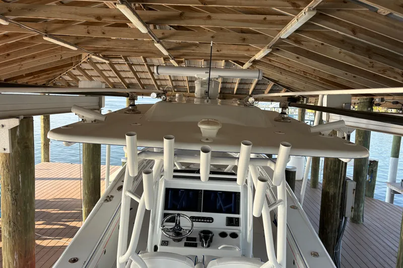 Slide: The Image of 2024 Yellowfin 36 Offshore boat docked under wooden shelter. - 16