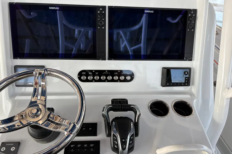 Slide: The Image of 2024 Yellowfin 36 Offshore boat dashboard with dual Simrad displays and steering wheel. - 17