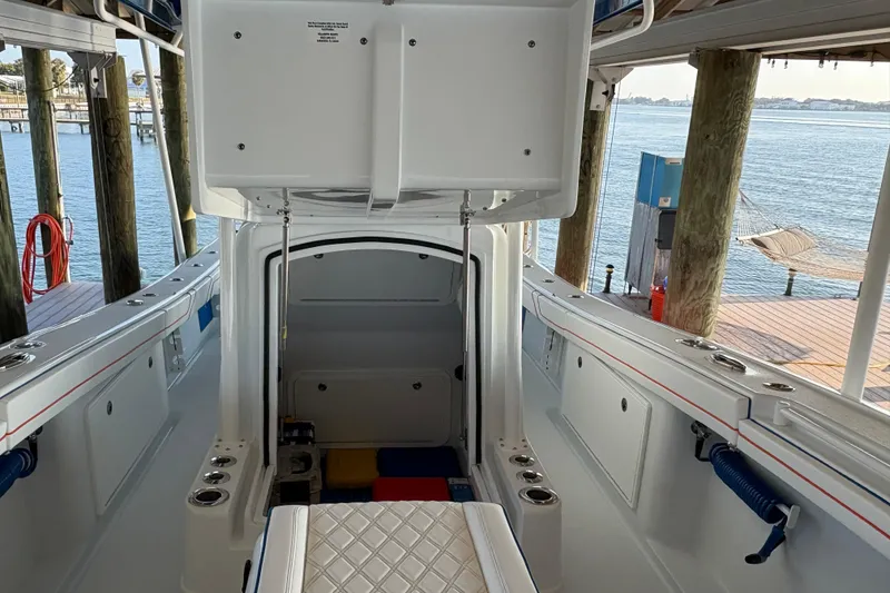 Slide: The Image of 2024 Yellowfin 36 Offshore boat interior with open storage compartment, dockside view. - 21