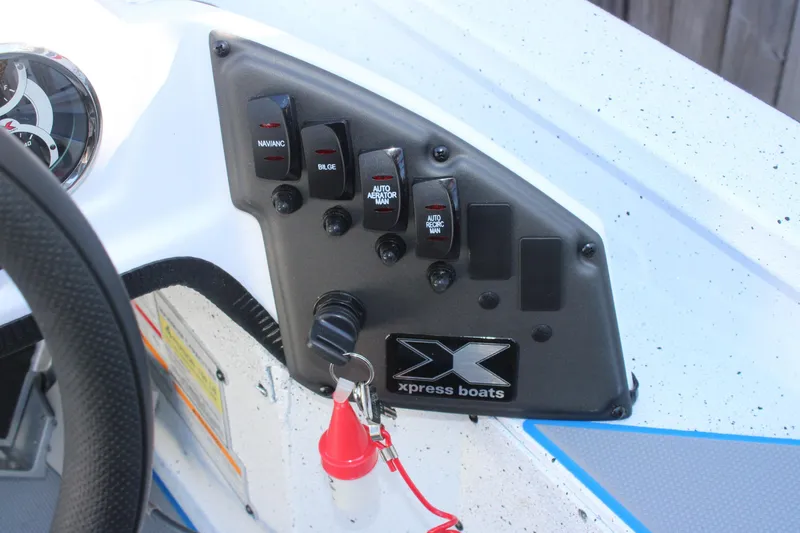 Slide: The Image of Control panel of 2026 Xpress H20 boat with switches and key ignition. - 10