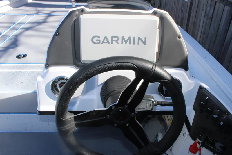 Slide: The Image of Steering wheel and Garmin display on 2026 Xpress H20 boat dashboard. - 11