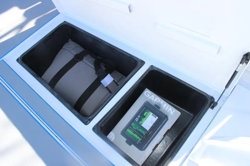 Slide: The Image of Open storage compartments on Xpress H20 boat, featuring a bag and Garmin device. - 25