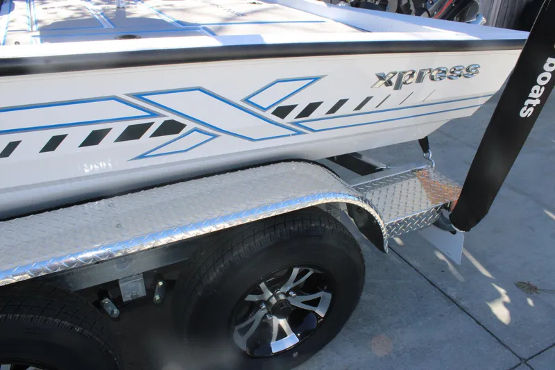 Slide: The Image of 2026 Xpress H20 boat on a trailer with stylish graphics and chrome wheels. - 7