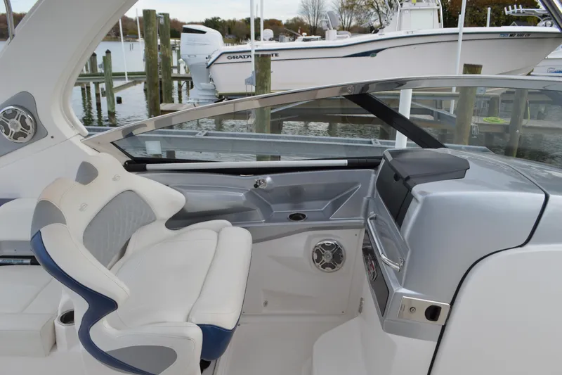 Slide: The Image of 2013 Chaparral 327 SSX boat cockpit with helm and seating at marina. - 24