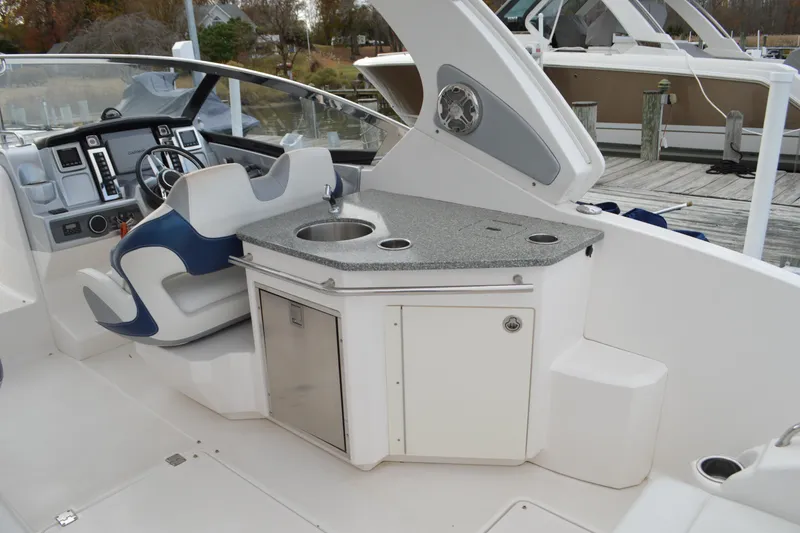 Slide: The Image of 2013 Chaparral 327 SSX boat interior with helm and kitchenette area. - 25