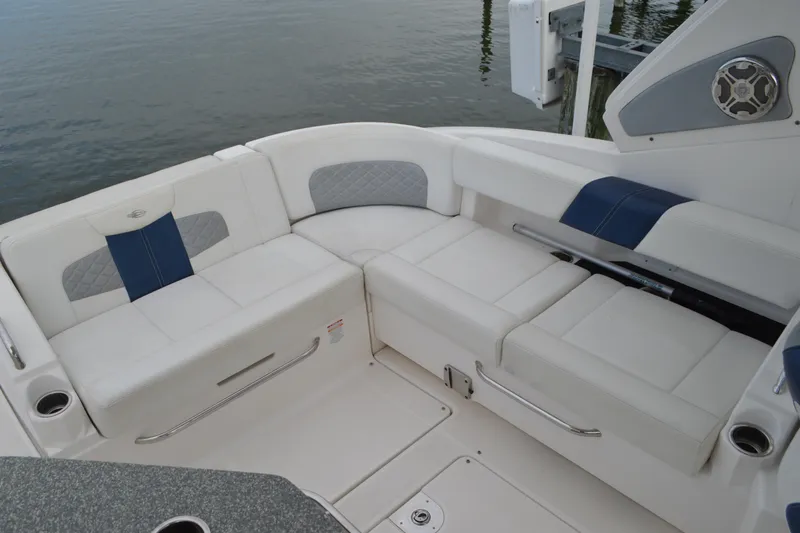 Slide: The Image of 2013 Chaparral 327 SSX boat interior with white and blue seating by the water. - 26