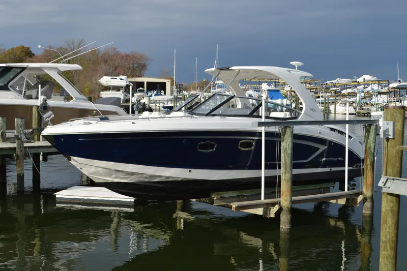 Slide: The Image of 2013 Chaparral 327 SSX boat docked at marina, featuring sleek design and blue hull. - 3