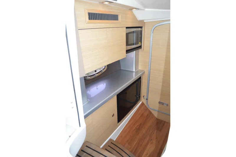 Slide: The Image of 2013 Chaparral 327 SSX boat interior with modern kitchenette and wood flooring. - 34