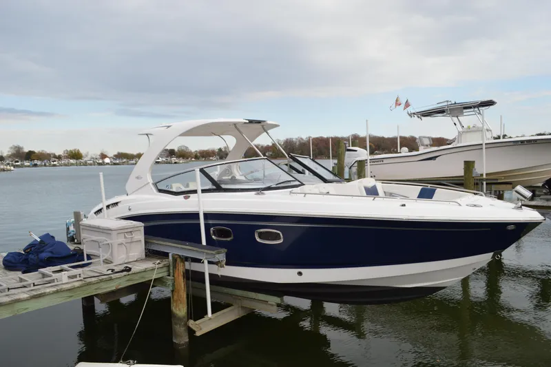Slide: The Image of 2013 Chaparral 327 SSX boat docked at a marina, featuring sleek design and blue hull. - 4