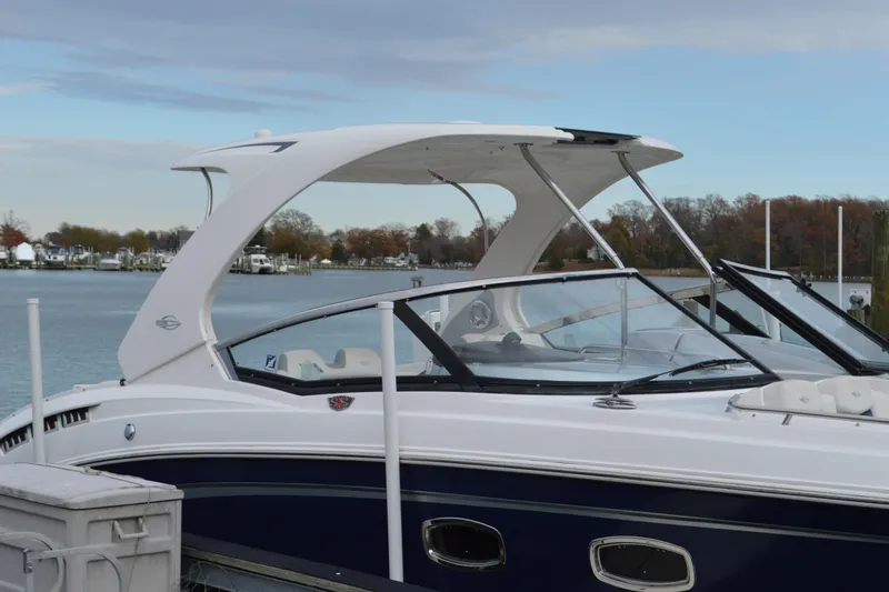 Slide: The Image of 2013 Chaparral 327 SSX boat docked by a serene waterfront. - 6