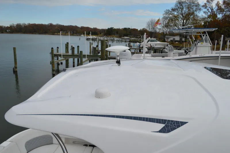 Slide: The Image of 2013 Chaparral 327 SSX boat docked by a serene lake with clear skies. - 7