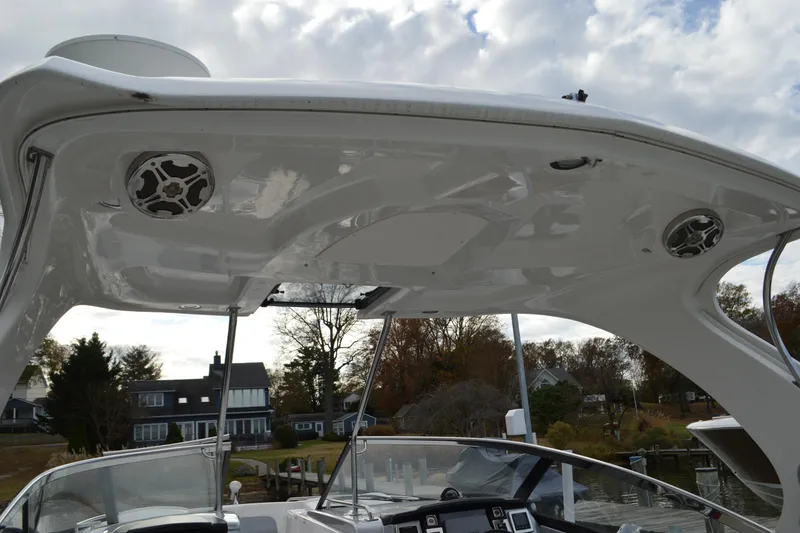 Slide: The Image of 2013 Chaparral 327 SSX boat with sleek white canopy and built-in speakers. - 8