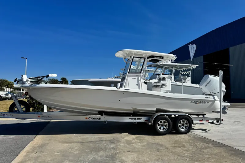 The Image of 2026 Caymas 28 HB boat on trailer, parked outdoors under clear blue sky. - 1