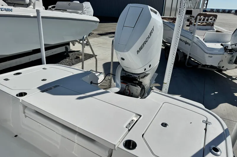 Slide: The Image of 2026 Caymas 28 HB boat with Mercury outboard motor, docked in a marina. - 10