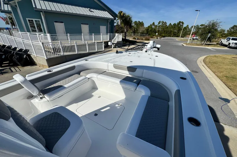 Slide: The Image of 2026 Caymas 28 HB boat with spacious seating, docked near a coastal building. - 25