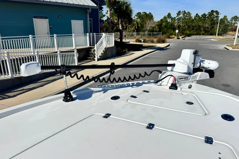 Slide: The Image of 2026 Caymas 28 HB boat with Minn Kota trolling motor at a dockside location. - 27