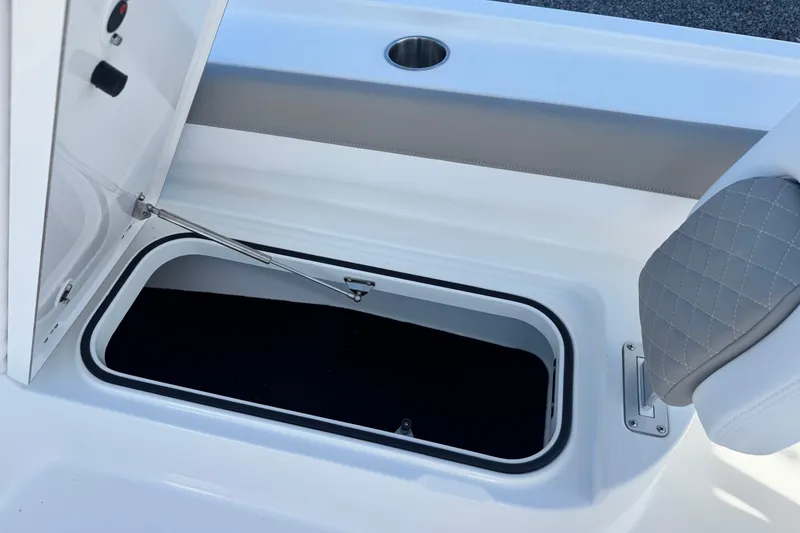 Slide: The Image of 2026 Caymas 28 HB boat storage compartment with open hatch and cushioned seating. - 29