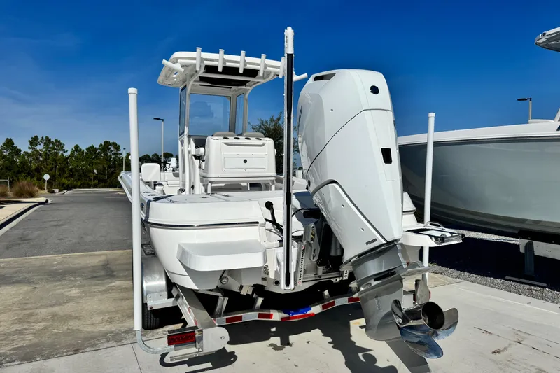 Slide: The Image of 2026 Caymas 28 HB boat with powerful outboard motor, parked on a sunny day. - 5