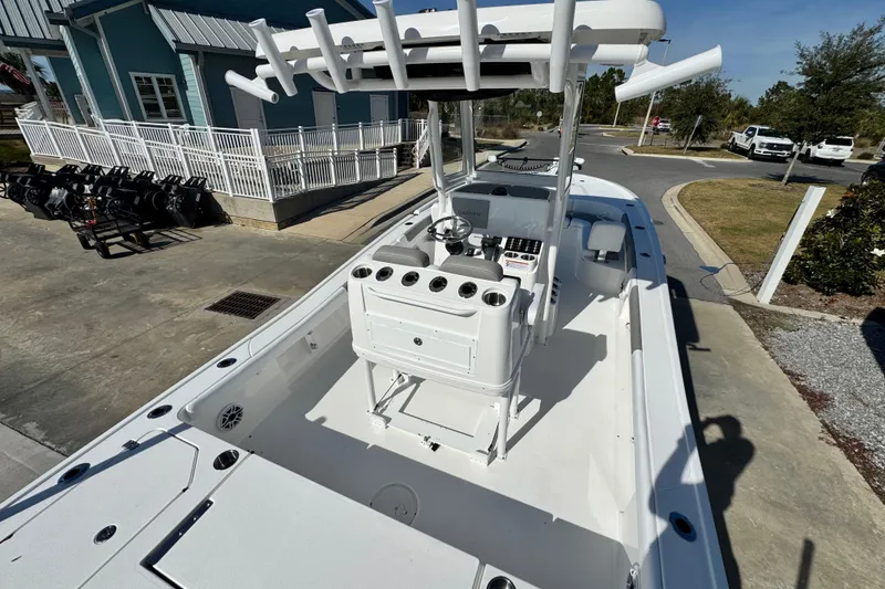 Slide: The Image of 2026 Caymas 28 HB boat with center console, docked near a blue building. - 9