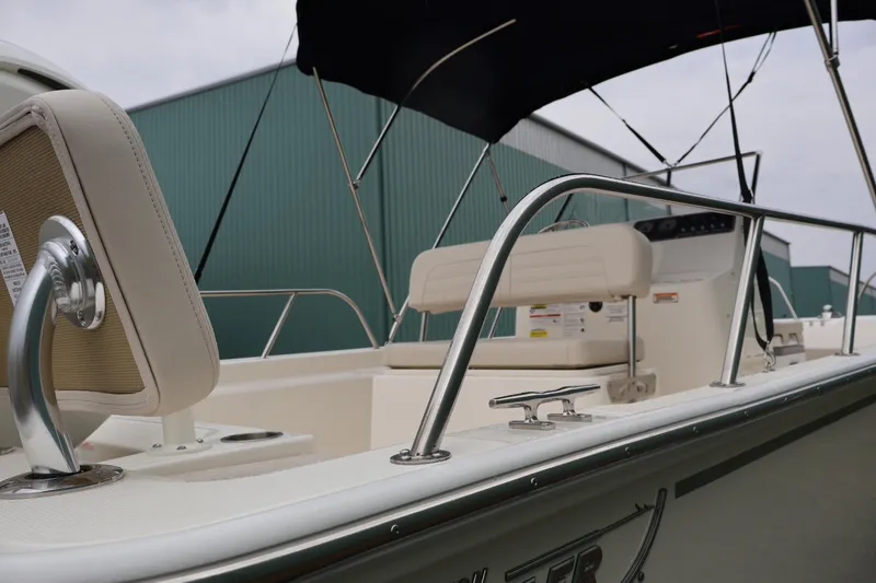 Slide: The Image of 2026 Boston Whaler 190 Montauk boat interior with seating and railing, under a canopy. - 10