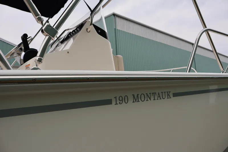 Slide: The Image of 2026 Boston Whaler 190 Montauk boat side view with visible console and railing. - 12