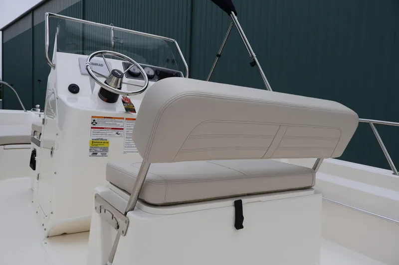 Slide: The Image of 2026 Boston Whaler 190 Montauk boat interior with steering console and cushioned seating. - 13
