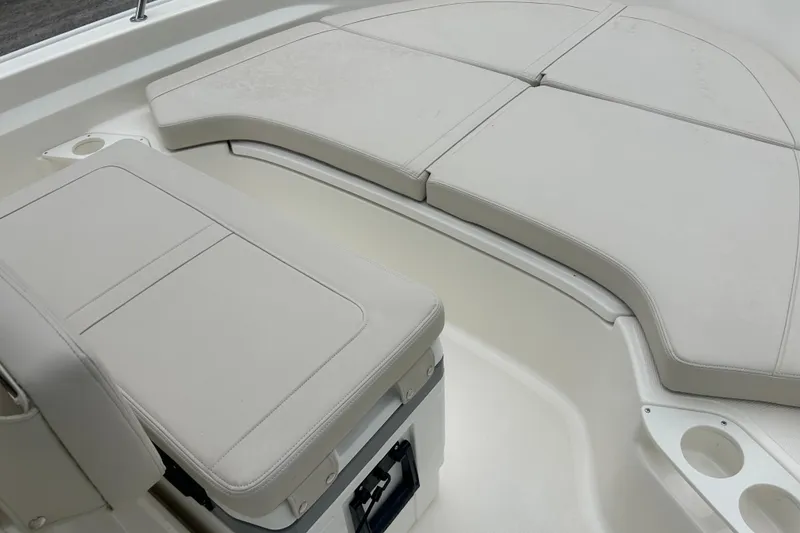 Slide: The Image of 2026 Boston Whaler 190 Montauk interior seating with cushioned storage and cup holders. - 21