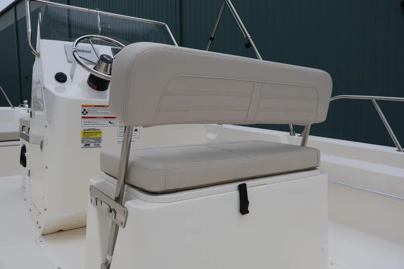Slide: The Image of 2026 Boston Whaler 190 Montauk boat interior with steering console and cushioned seating. - 26