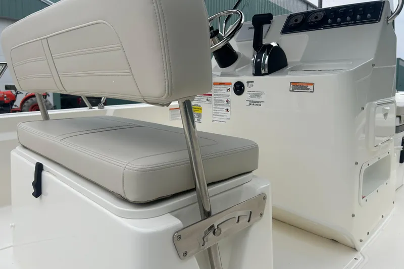 Slide: The Image of 2026 Boston Whaler 190 Montauk boat interior with steering console and cushioned seating. - 27
