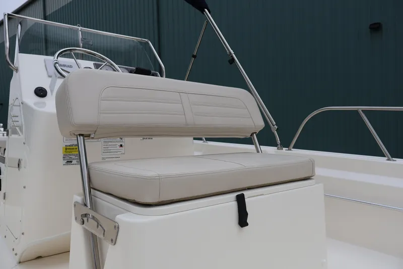 Slide: The Image of 2026 Boston Whaler 190 Montauk boat interior with beige seating and steering console. - 29