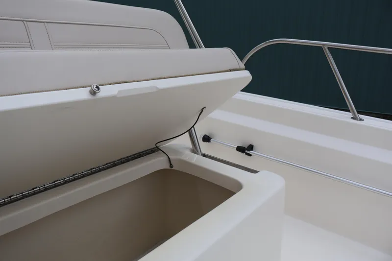 Slide: The Image of 2026 Boston Whaler 190 Montauk boat storage compartment with open lid and railing. - 30