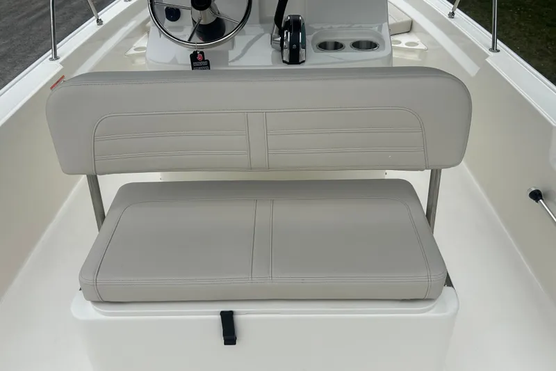Slide: The Image of 2026 Boston Whaler 190 Montauk boat interior with cushioned seating and steering console. - 31