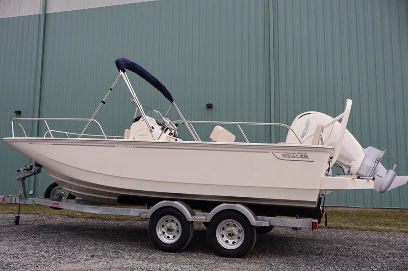 Slide: The Image of 2026 Boston Whaler 190 Montauk boat on trailer, parked outdoors. - 6