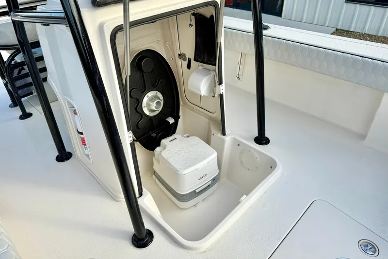 Slide: The Image of 2026 Carolina Skiff 26 Ultra Elite boat interior with portable toilet and storage compartment. - 21