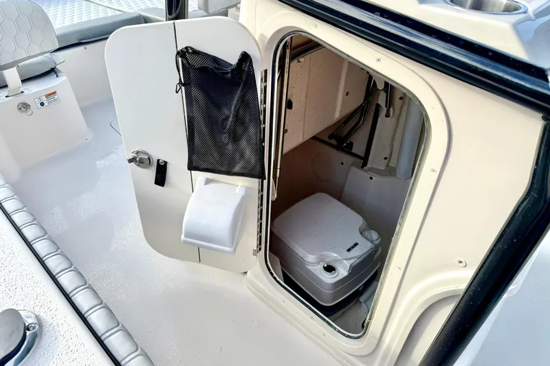 Slide: The Image of 2026 Carolina Skiff 26 Ultra Elite boat interior with compact toilet compartment. - 30