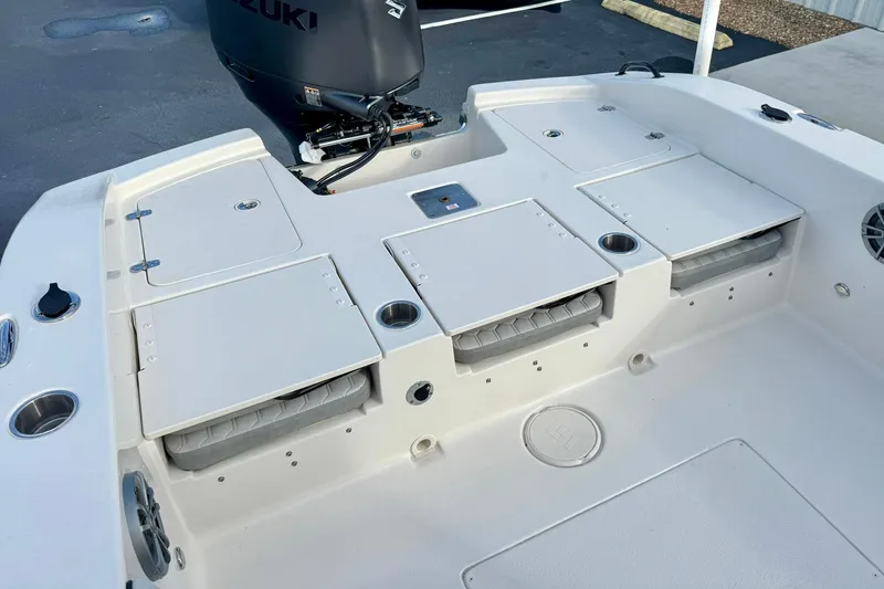Slide: The Image of 2026 Carolina Skiff 26 Ultra Elite boat deck with storage compartments and Suzuki outboard motor. - 36