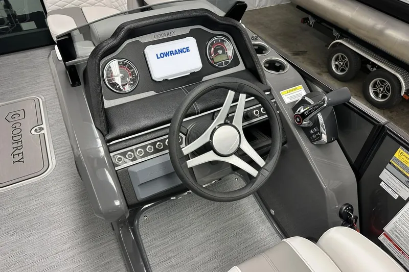 Slide: The Image of 2026 Godfrey Monaco 235 SFL boat dashboard with steering wheel and control panel. - 5