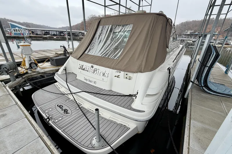 Slide: The Image of 1995 Sea Ray 370 Sundancer docked at marina with brown canopy. - 2