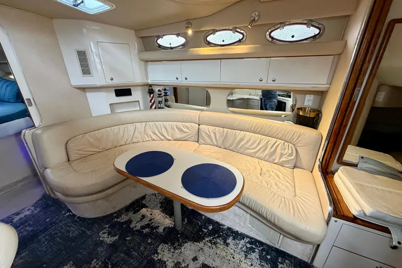 Slide: The Image of Interior of 1995 Sea Ray 370 Sundancer with beige seating and oval windows. - 22