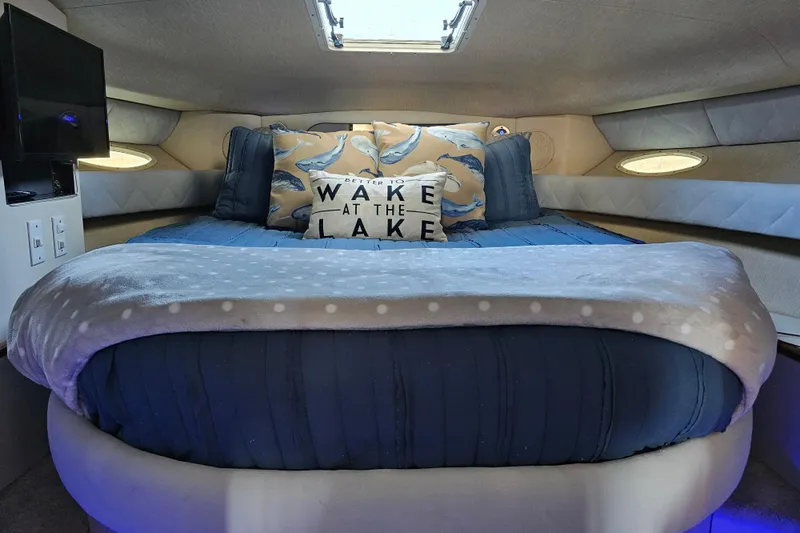 Slide: The Image of Cozy cabin interior of 1995 Sea Ray 370 Sundancer with plush bedding and decorative pillows. - 28
