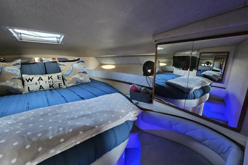 Slide: The Image of Cozy cabin interior of 1995 Sea Ray 370 Sundancer with blue bedding and decorative pillows. - 29