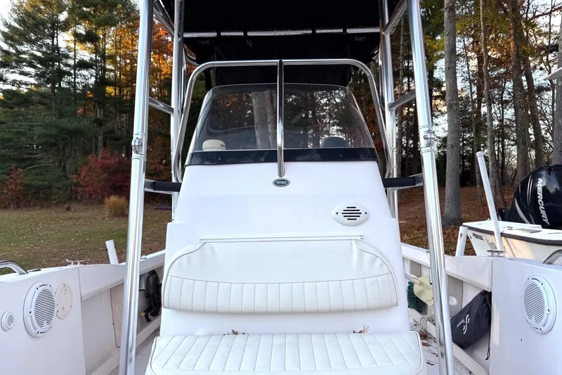 Slide: The Image of 2004 Grady-White Fisherman 180 boat interior with seating and console, surrounded by trees. - 12