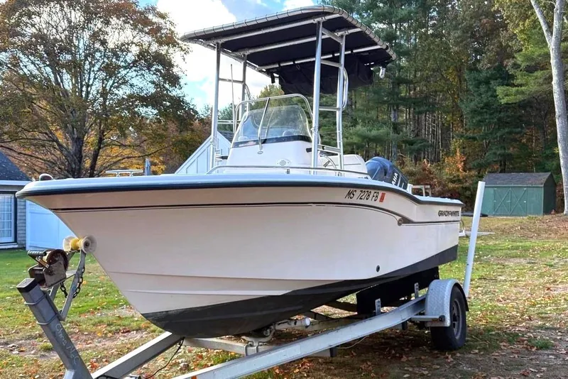 Slide: The Image of 2004 Grady-White Fisherman 180 boat on trailer, parked outdoors with trees in background. - 2
