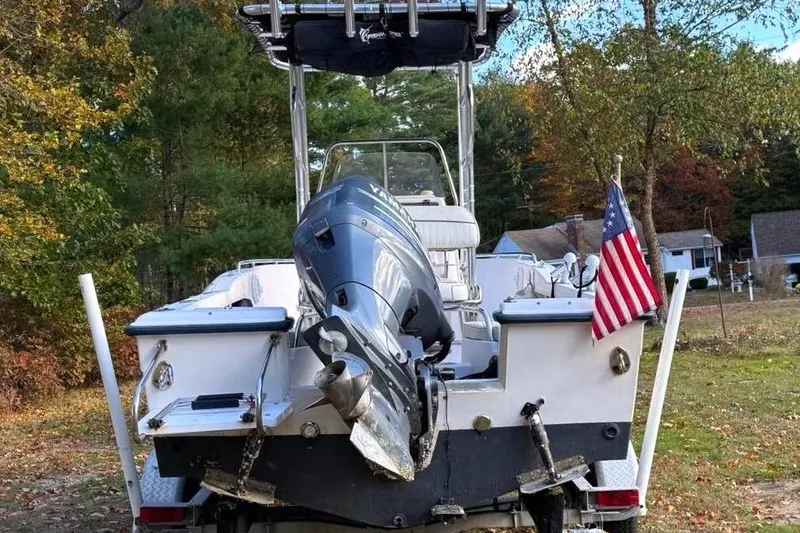 Slide: The Image of 2004 Grady-White Fisherman 180 boat with outboard motor and American flag, parked outdoors. - 3