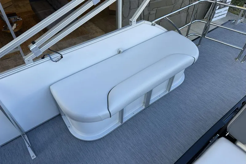 Slide: The Image of 2026 Godfrey Sweetwater 2286 SFLC boat with white cushioned seating and metal railings. - 11