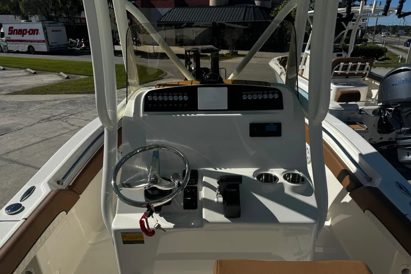 Slide: The Image of 2026 Pioneer 222 Islander boat dashboard with steering wheel and controls. - 17